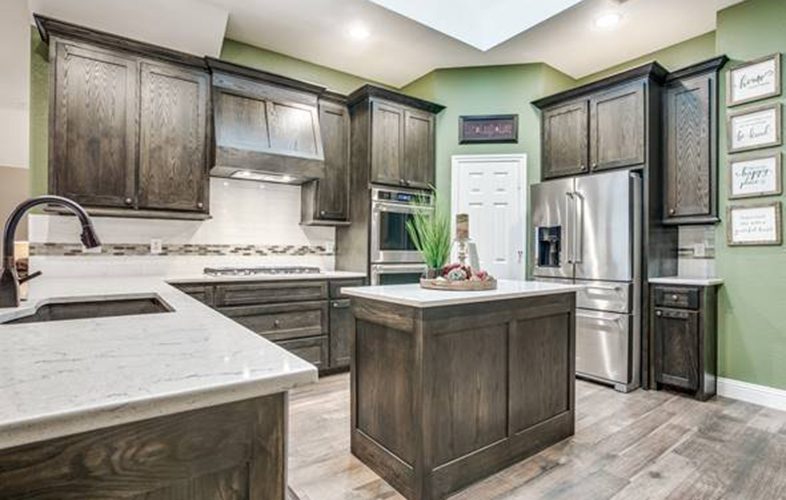 Remodeled kitchen with natural wood cabinets and green accents