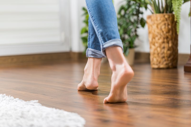 a person walking barefoot on freshly laid wood floors