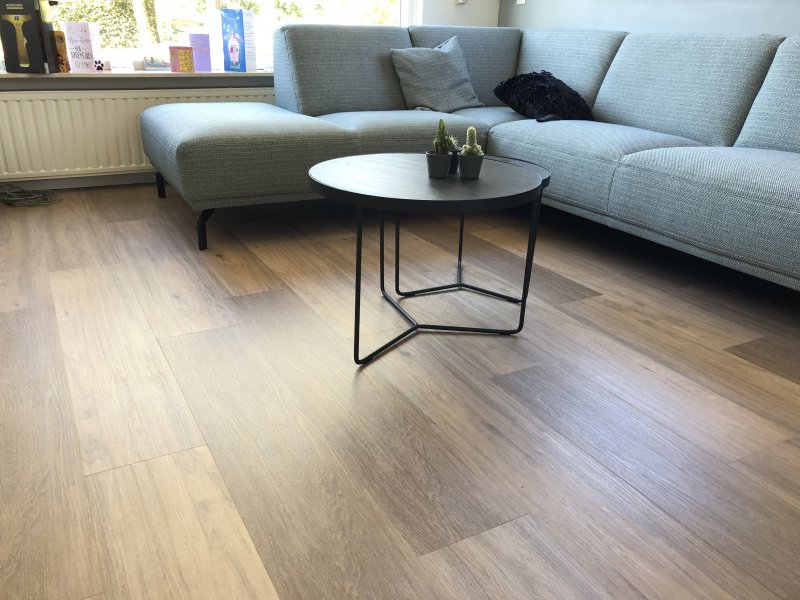 a living room complete with a sectional couch, coffee table, and textured flooring