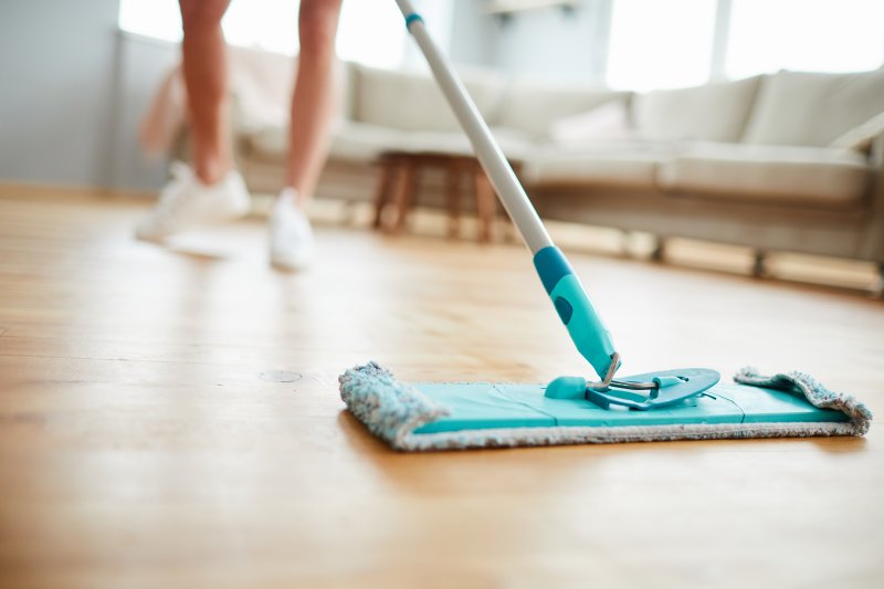 an up-close image of a person cleaning their floors with a modern mop