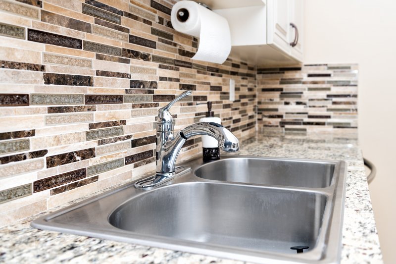 an up-close look of a kitchen sink, complete with a detailed backsplash