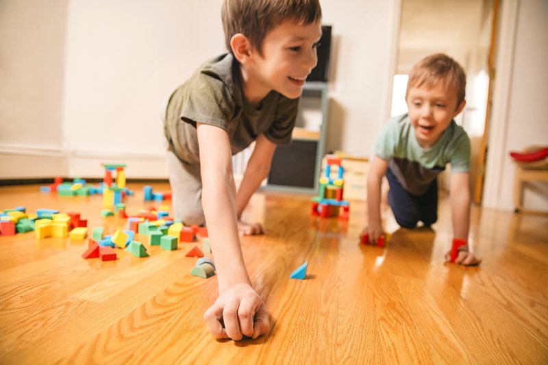 kids playing with blocks and cars on wood floor