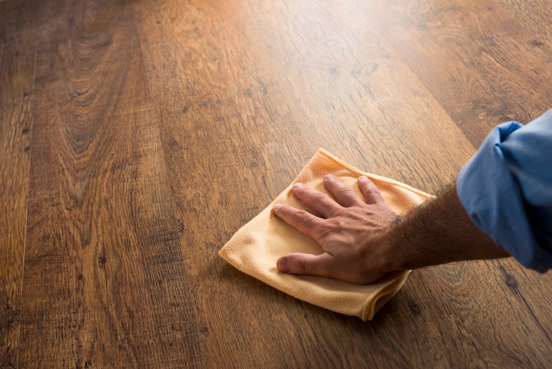 a person cleaning a wood floor