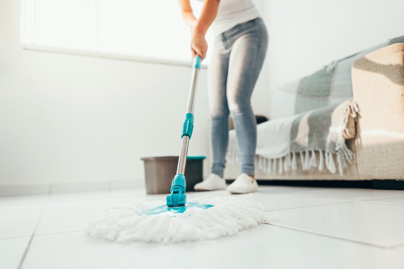 person cleaning floors with mop