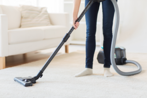 a person vacuuming their home’s carpet flooring